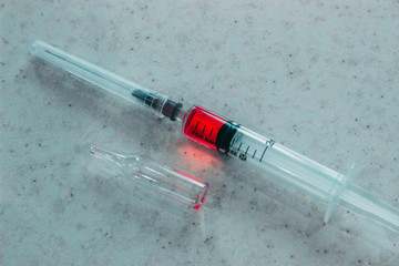Syringe with red solution on white background