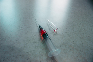 Syringe with red solution on white background