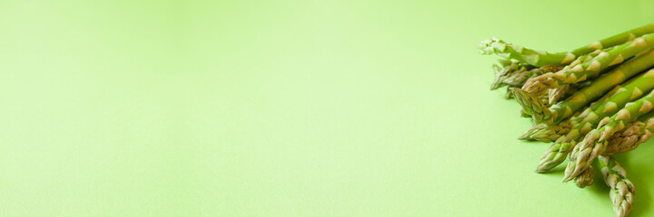 Fresh green asparagus on green background with copy space. Banner