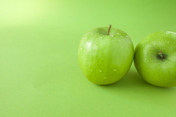 Perfect Fresh Green Apple Isolated on green Background with water drop in Full Depth of Field