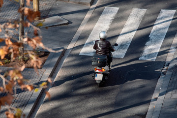 Man in a leather jacket driving a scooter in Barcelona  