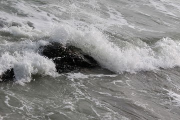 strong sea waves and foam with stones in the sea