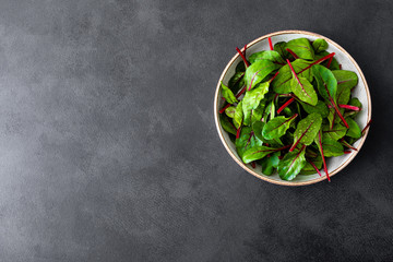 Fresh chard leaves on black background top view