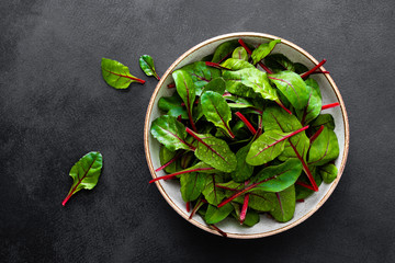 Fresh chard leaves on black background top view