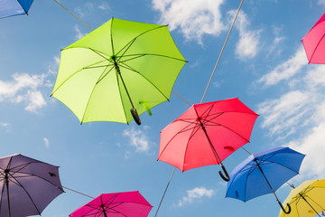 Umbrellas in many colors in Vejle, Denmark. Colorful umbrellas background. Hanging umbrellas over blue sky.