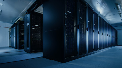 Shot of a Working Data Center With Rows of Rack Servers. Led Lights Blinking and Computers are...