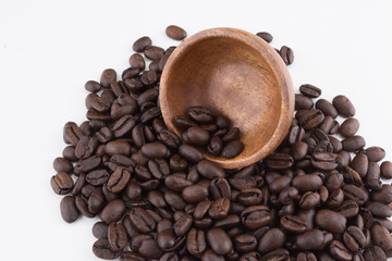 Stack of coffee beans with wooden bowl