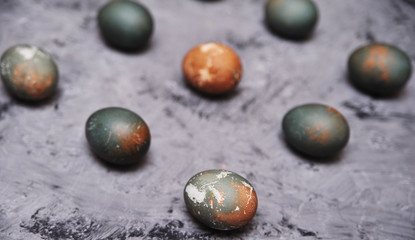 Chicken painted eggs in box on stone background.