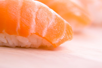 set of sushi on a wooden board with leaves of plants on a dark background