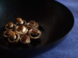 Mushrooms in hoarfrost. Frozen mushrooms in a skillet. Mushrooms in hoarfrost on a black skillet.