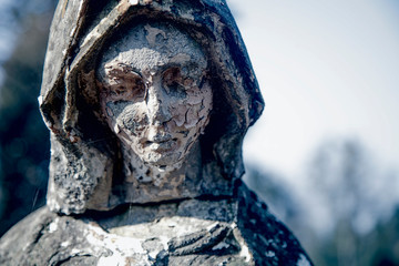 Vintage statue of sad woman in grief. Religion, faith, suffering, love concept.