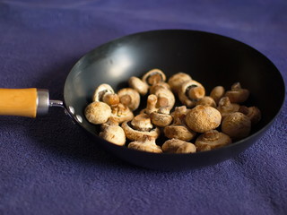 Mushrooms in hoarfrost. Frozen mushrooms in a skillet. Mushrooms in hoarfrost on a black skillet.