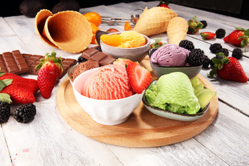 Set of ice cream scoops of different colors and flavours with berries, chocolate and fruits.
