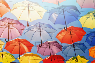 Fototapeta na wymiar Colorful umbrellas on the sky background, toned.