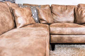 Elegant modern room closeup of leather couch and fluffy rug in staging model house, home or...