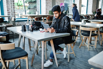 Smart young asian man photographer working with tablet during sitting at cafe.