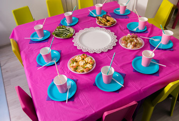 First baby girl birthday party concept. Table for kids and decor items in bright pink colors.