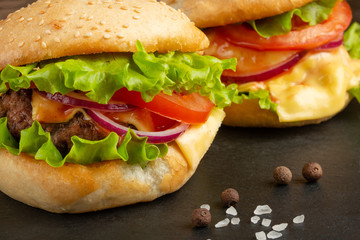 Delicious homemade burgers, burgers with beef, cheese, tomatoes, and salad. close up macro