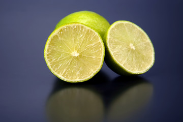 Cut citrus fruit of green lemon on blue background
