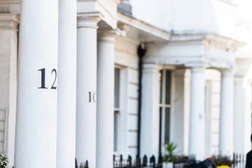 London neighborhood district of Pimlico with terraced housing balconies buildings and numbers on columns closeup in old vintage historic traditional style flats