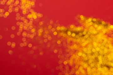 Golden blury glitter on red background.