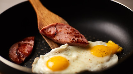 Fried eggs in a pan with sausage
