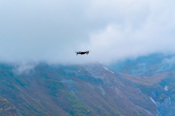 Fototapeta na wymiar Drone, a quadrocopter in the air, shoots the autumn mountain landscape in the mountains of Gudauri, Georgia.