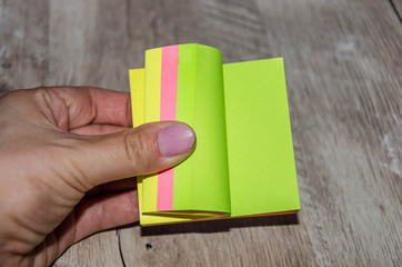 hand and colored paper on a wooden table