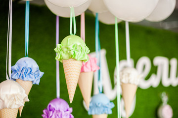 Decorations for the party. Huge colored ice-creams from paper and fabric. Green background