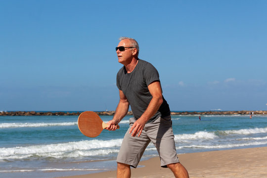 portrait of a man playing beach tennis