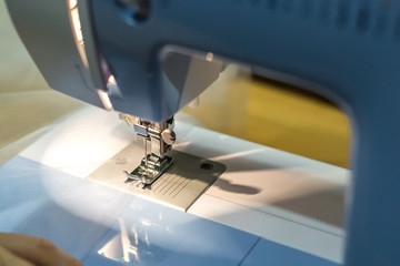 close up mechanism of sewing machine foot  with needle and thread