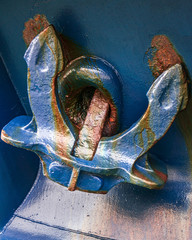 Closeup of a fishing boat heavy Hall anchor painted blue with rust coming through the paint. © Gabriel