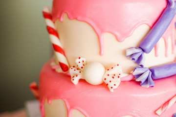Birthday pink cake with candies and lolly-pops, different details