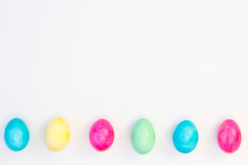 Six colored eggs on white background
