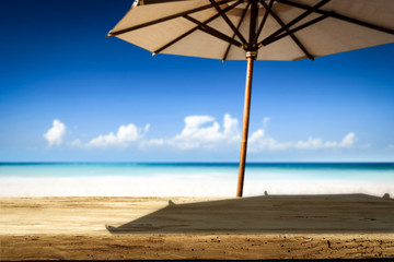 Desk of free space on beach and umbrella with shadow 