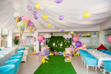 Birthday party concept, decorations for sweet party. Huge number one, table with sweets and desserts, cloud from balloons and ice-creams, a lot of colored balloons and big candy toys