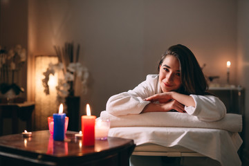 Spa, massage. A young dark-haired beautiful girl is waiting for a massage.