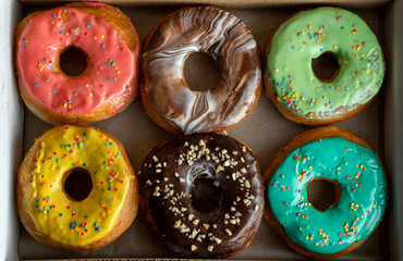 Delicious and tempting box full of colour donuts.