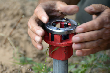 Male hands hold pipe screw die.