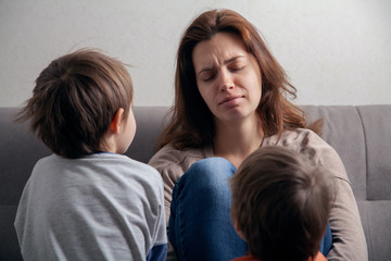  Woman mom is tired in depression and children are boys.