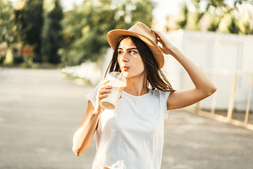 Brunette pretty tourist girl outdoor with cup of cold coffee.