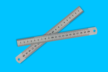 Pair of metal straightedges with digits and scale on blue background