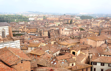 Fototapeta na wymiar Tile roofs of city Siena of Italy. Tuscany old houses
