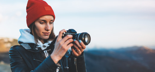 hipster tourist girl hold in hands take photography click on modern photo camera, photographer look...
