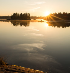 Man Canoeing at Sunrise on Lake