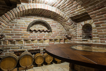 Wooden table and wine barrels in basement