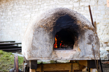 Traditional cooking in an ancient clay oven. Open fire Cooking for many people. Outdoor cooking in...