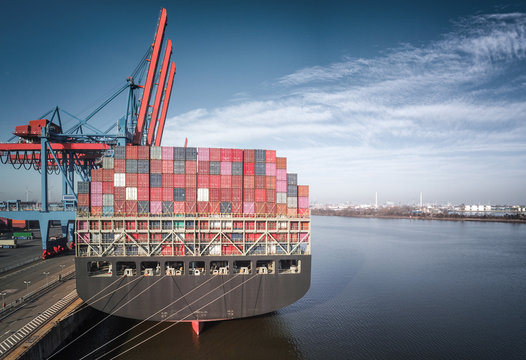 Containerschiff im Hamburger Hafen bei besten Wetter mit Elbphilharmonie im Hintergrund