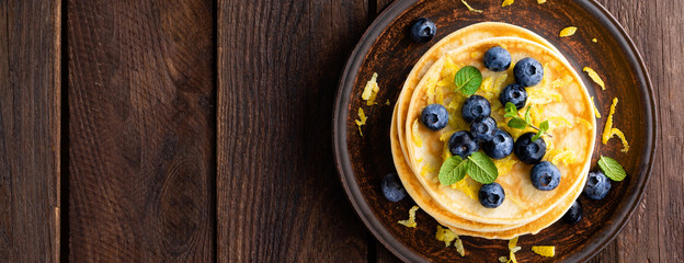 Pancakes with fresh blueberry on wooden rustic background. Top view. Banner
