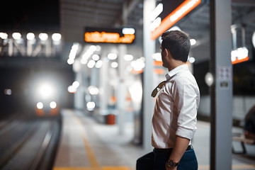 Young attractive businessman waiting for train in metro or subway.